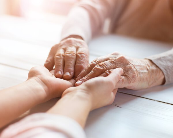 Die Hände einer jüngeren Person reichen die Hände einer älteren Person | © Halfpoint - Fotolia