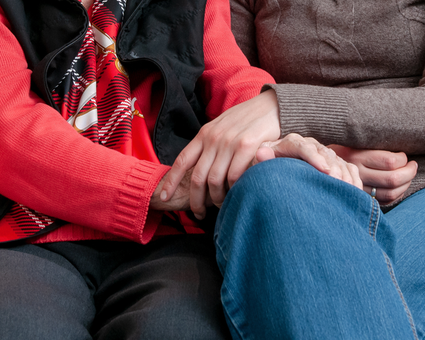 Zwei Frauen halten sich gegenseitig ihre Hände | © Caritas München und Oberbayern